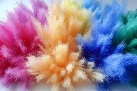 Vibrant multicolored powder explosion with pink, blue, yellow and green hues bursting outward creating dynamic motion effect for creative projects.