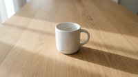 White ceramic mug on wooden table with natural sunlight casting shadows, ready for mockup designs, branding, and product presentations.