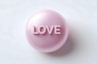 Pink round candy or pill with embossed LOVE text on white background, minimal romantic concept design for valentines and wedding themes.