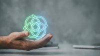 Male hand holding glowing atomic or molecular structure symbol, representing science, technology, innovation, and research concepts for educational and business presentations.