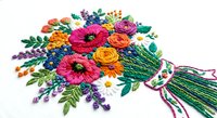 Colorful hand embroidered floral bouquet with vibrant threads on white fabric featuring decorative tassels for textile art and craft projects.