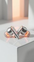 Wireless earbuds with glowing orange accents displayed on white pedestal. Modern audio technology product showcasing sleek metallic design and illuminated charging case details.