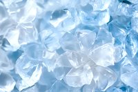 Macro shot of crushed ice cubes with blue tint background showing crystalline texture and translucent frozen water fragments in bright lighting conditions.