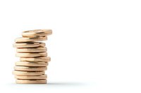 Stack of golden coins on white background, arranged in uneven tower formation showing financial growth and wealth concept. Isolated with copy space.