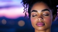 Young African American woman with natural curly hair and closed eyes against purple sunset sky background, expressing serenity and peace.