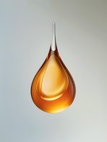 Amber liquid droplet with glossy finish isolated on neutral background, suitable for cosmetics, skincare, wellness and beauty product design applications.