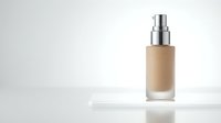 Foundation bottle with pump dispenser on white surface against neutral background for cosmetic product photography and beauty brand marketing.