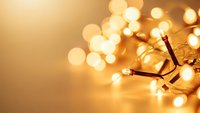 Warm golden string lights with soft bokeh glow creating cozy ambient atmosphere for holiday decorations and festive celebrations.