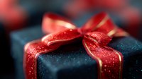 Elegant black gift box wrapped with sparkling red satin ribbon and bow against dark background, macro close-up view showing festive holiday details and texture.