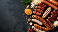 Grilled assorted sausages with sauerkraut, mustard sauce and fresh herbs arranged on dark background with copy space for menu or recipe design.