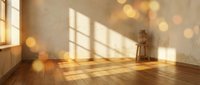 Empty room interior with warm sunlight streaming through window creating golden bokeh effects on wooden floor and beige walls for home design projects.