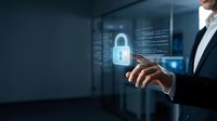 Professional businessman holding glowing digital padlock icon representing cybersecurity and data protection in modern server room environment.