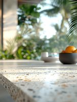 Elegant terrazzo countertop with bowl of oranges and tropical palm view through window, creating luxurious kitchen atmosphere for interior design projects.