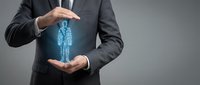 Businessman in dark suit holding glowing digital human figure between hands, representing recruitment, talent management, and personnel selection for corporate business concepts.