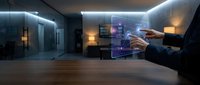 Man in business suit interacting with holographic digital interface displaying data visualization in modern office space with ambient lighting and wooden flooring.