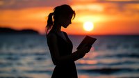 Silhouette of young woman reading book against dramatic orange sunset over ocean waves, creating peaceful solitary moment at beach during golden hour.