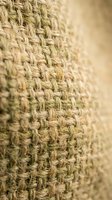 Natural jute burlap fabric texture with woven hemp fibers in beige tones for rustic eco-friendly craft and packaging design projects.