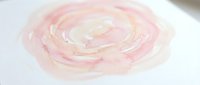Pink and white swirled cream or frosting texture with smooth glossy finish on white background, perfect for bakery and dessert design projects.