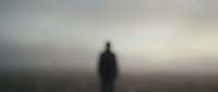 Mysterious silhouette of person standing in foggy landscape with dramatic atmospheric lighting creating moody and contemplative scene for creative projects.