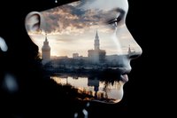 Double exposure portrait of young Asian woman's profile merged with dramatic cityscape at sunset, reflecting urban architecture and water reflections in silhouette.
