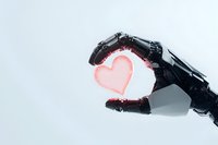 Black robotic hand forming heart shape against white background, glowing pink heart light effect between mechanical fingers, modern technology meets emotion.