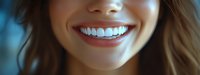 Close-up of young woman with bright white smile and perfect teeth against blue background, showcasing dental health and confidence.