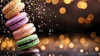 Colorful French macarons stacked in row with golden bokeh lights background, soft focus dessert photography with festive sparkle and warm glow effect.