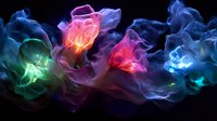 Ethereal glowing flowers created from colorful smoke and light effects against dark background, featuring vibrant pink, blue, green and turquoise hues in flowing motion.