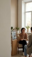 Young woman patient waiting in modern medical clinic reception area with plants and natural lighting for healthcare appointment consultation.