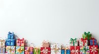 Colorful wrapped gift boxes with bows arranged in a row on white background, suitable for holiday greeting cards, promotional materials, and festive design projects.