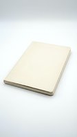 Closed cream colored notebook with blank cover isolated on white background for mockup design and branding projects.