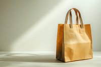Brown paper shopping bag with leather handles on light background with dramatic shadow. Minimalist eco-friendly retail and sustainable packaging concept.