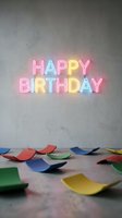 Colorful neon Happy Birthday sign glowing on a concrete wall with scattered confetti pieces on the floor, festive party celebration concept.