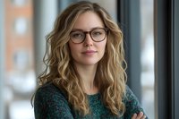 Professional blonde businesswoman with glasses and crossed arms in modern office setting for corporate presentations and marketing materials.