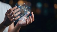 Hands holding glowing digital network sphere with connected nodes and light effects representing global connectivity, technology innovation and data visualization.
