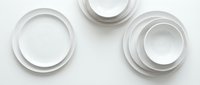 Stacked white ceramic bowls and plates arranged on neutral background, isolated kitchenware for tableware design and culinary projects.