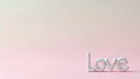 Minimalist love text on soft pink gradient background for romantic designs, valentines day cards, wedding invitations and relationship concepts.