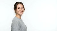 Smiling woman with brown hair wearing gray sweater, isolated on white background, suitable for portrait, lifestyle, and business design projects.