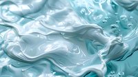 Swirling turquoise and white liquid creates abstract waves and bubbles in macro photography, showing fluid dynamics and artistic motion patterns in soothing aqua tones.