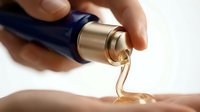 Cosmetic serum or oil pouring from dropper bottle onto skin, skincare product application and beauty treatment.