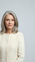 Mature woman with shoulder-length gray hair and fair complexion wearing cream-colored textured cardigan against neutral background. Professional portrait suitable for corporate, business, healthcare, and lifestyle editorial use.