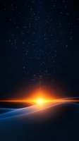 Glowing sunrise over snowy hills against starry night sky, creating dramatic contrast between warm orange light and cool blue shadows on winter landscape.