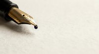 Elegant gold fountain pen nib on textured paper surface, close-up macro shot for writing, calligraphy, business correspondence and luxury stationery concepts.