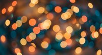 Abstract bokeh lights background with warm orange yellow and cool blue circular light spots creating dreamy blurred illumination for festive designs.