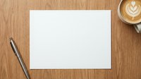 Blank white paper sheet on wooden desk with coffee cup and pen, mockup template for business documents, letters, notes or creative writing projects.