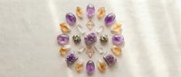 Healing crystals arranged in sacred geometry circle with amethyst and citrine gemstones on white marble surface for meditation and spiritual wellness practices.