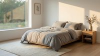 Cozy bedroom interior with unmade bed featuring neutral bedding, wooden nightstand, dried flowers in vase, and natural sunlight from large window overlooking garden landscape.