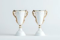 Elegant white decorative vases with ornate golden handles on neutral background, symmetrical composition featuring antique-style ceramic urns for luxury home decor.