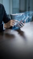 Businessman analyzing financial data on futuristic holographic tablet with charts and graphs in modern office environment for business analytics.