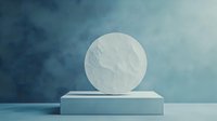 Minimalist marble circle on light blue pedestal against moody turquoise background with atmospheric fog effect, modern abstract composition for luxury branding.